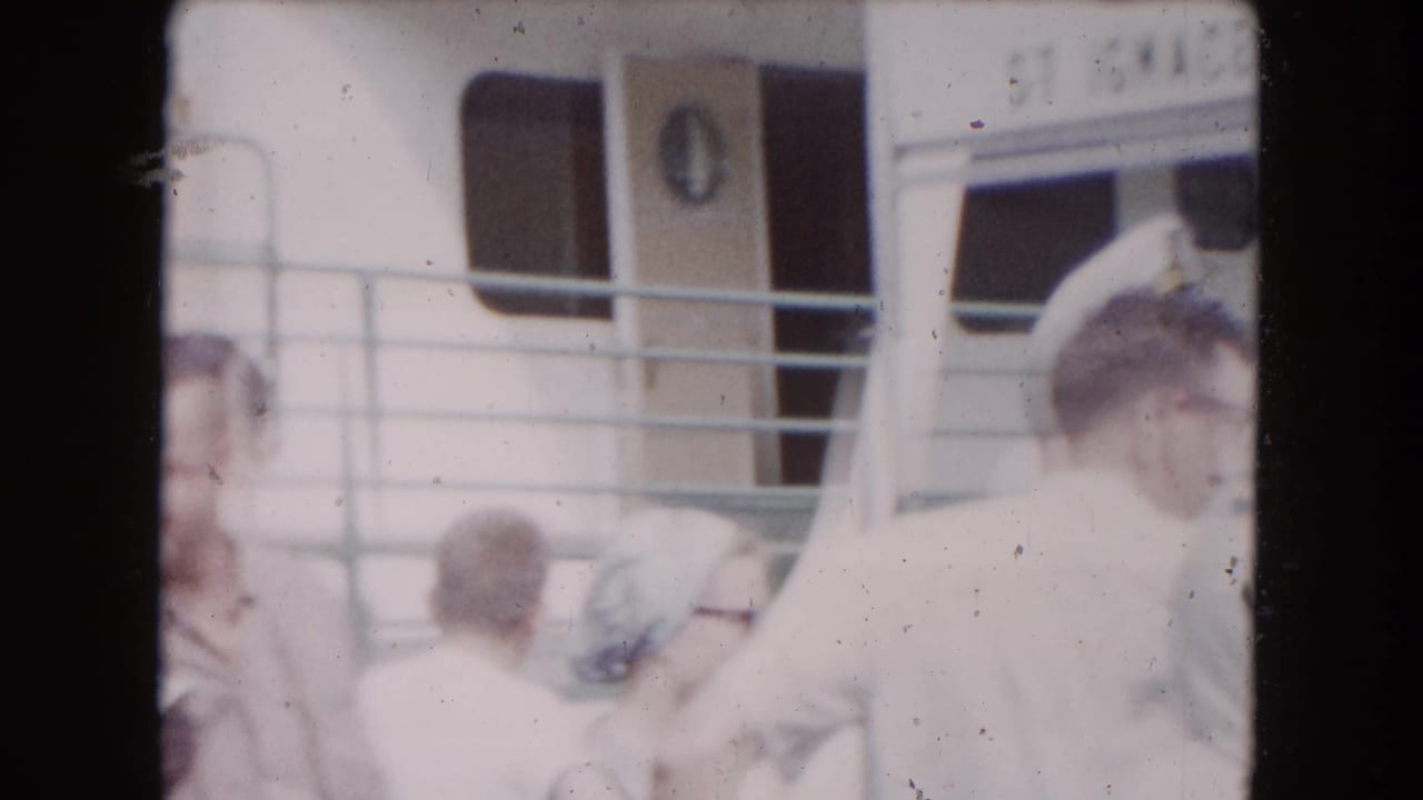 1961 8mm home-movie frame from Buffalo metadata showing passengers near a boat cabin, railings, windows, and a ST IGNACE sign.
