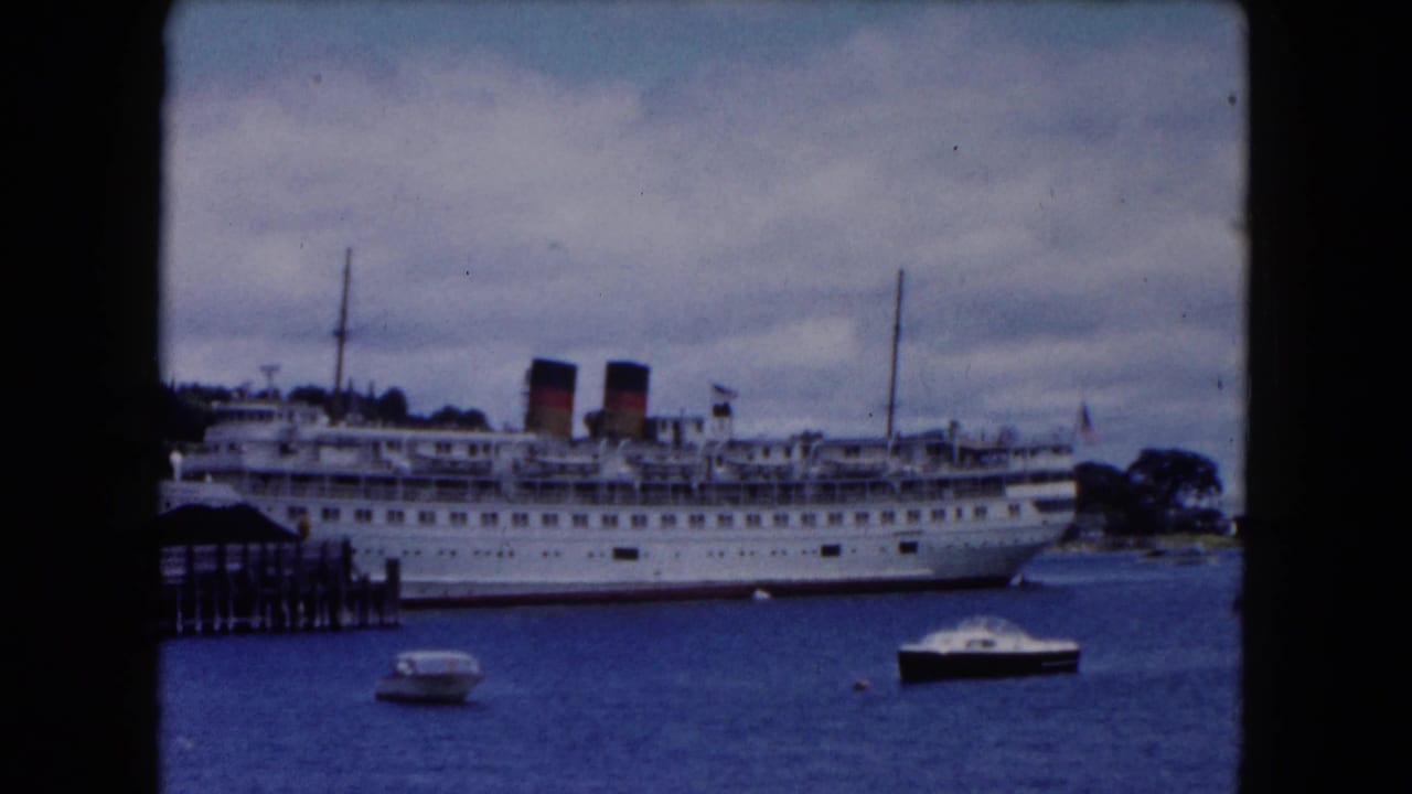 1961 Buffalo waterfront view of a large white passenger ship beside a pier, with small motorboats on blue water under cloudy sky.