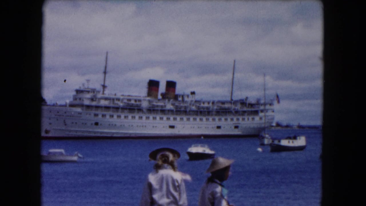 Passenger ship across the harbor with two visitors in hats entering the foreground.