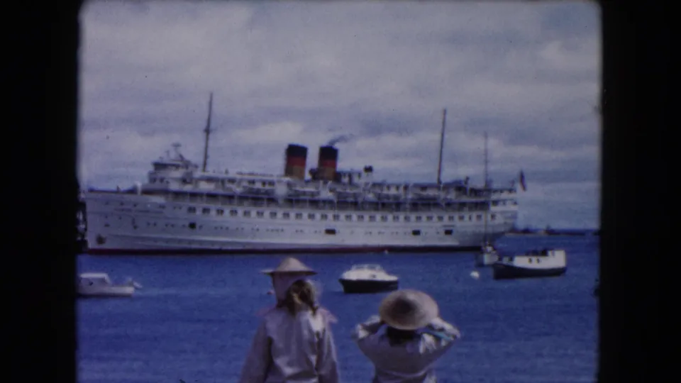 Buffalo, New York harbor in 1961 with a large passenger ship, small boats, and two visitors seen from behind.