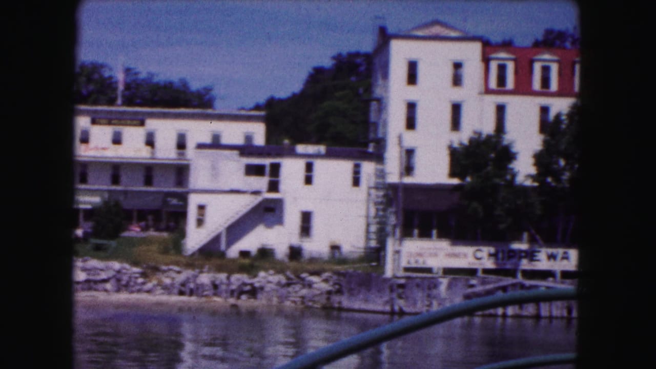 White hotel buildings and a partial hotel sign beside the river.