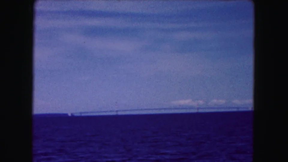 1961 Buffalo-area 8mm frame showing a distant bridge across open blue water under a lightly clouded sky.