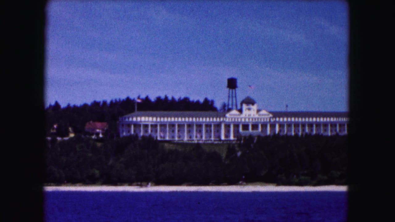Vintage 8mm frame of the white lakeside hotel near Buffalo, with the water tower rising behind the roofline.