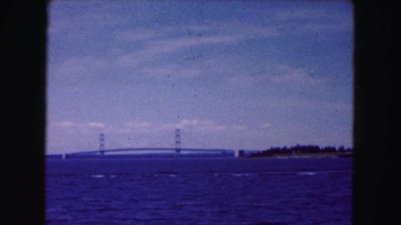 Bridge towers and span visible across water with shoreline at right.