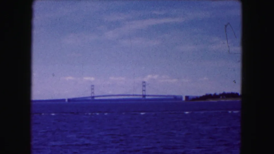 A wide 8mm frame shows rippling water, a distant bridge, and low shoreline, consistent with the supplied 1961 Buffalo location.