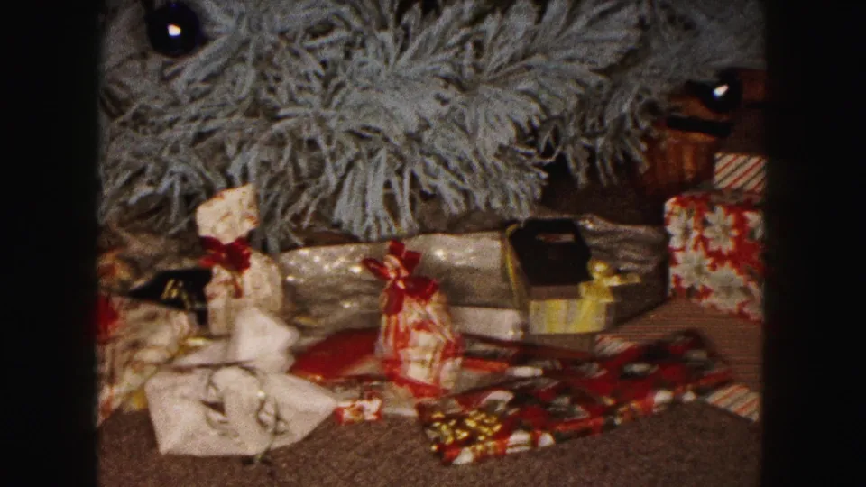 1961 Buffalo holiday home interior with a small artificial tree, wrapped gifts, loose ribbon, and a basket nearby.