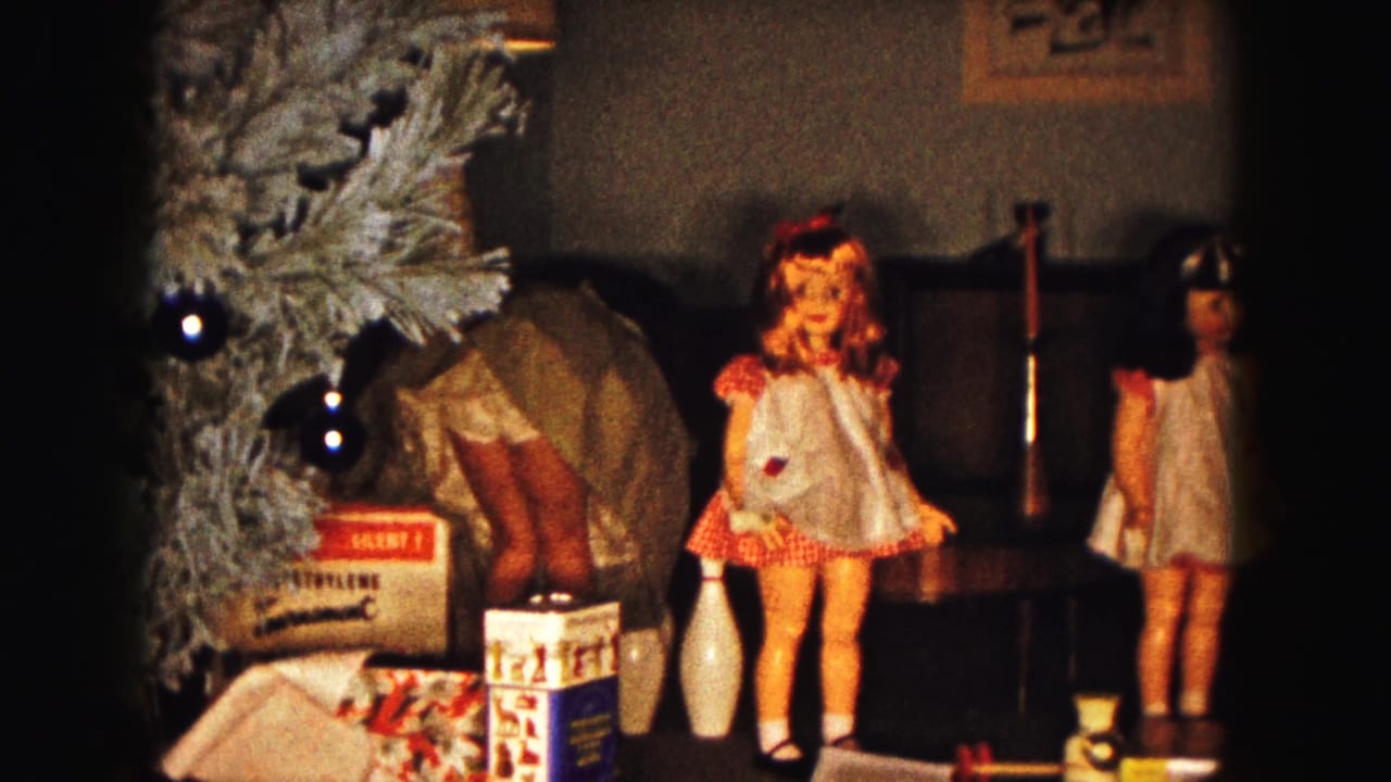 1961 Buffalo holiday interior with dolls in dresses, toy bowling pins, gift boxes, and an artificial Christmas tree.