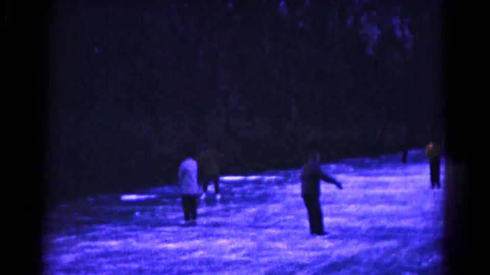Final 8mm frame of a few skaters on the blue-purple outdoor ice at night in 1961 Hagerstown.