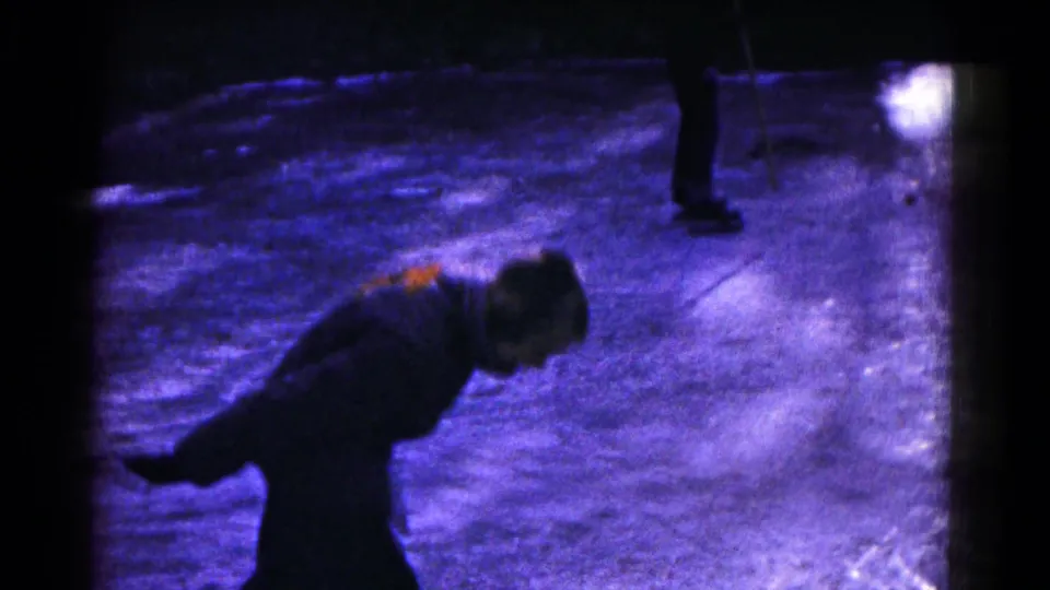 A bundled skater appears to lean forward while balancing on outdoor ice in 1961 Hagerstown home-movie footage.