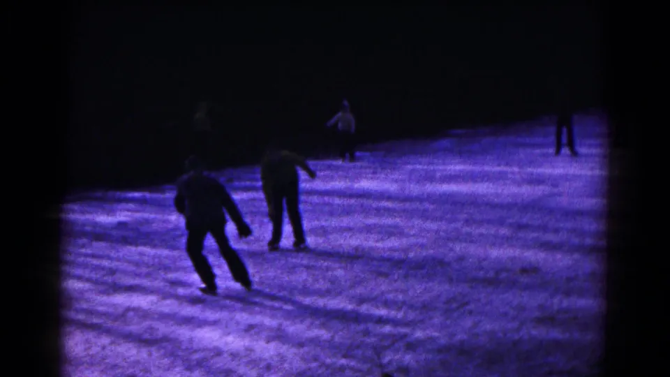 Night skating scene in Hagerstown, Maryland, with two central figures silhouetted against purple-blue ice.