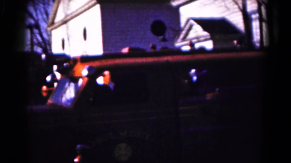 Vintage fire engine in Hagerstown, Maryland, seen from the side as it passes a residential block in 1961 home-movie footage.