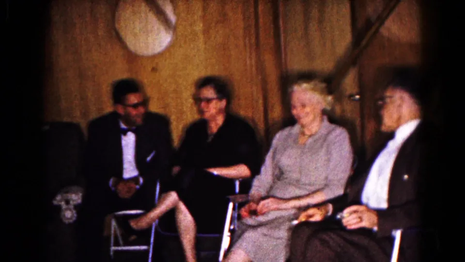 Four older adults sit together in a wood-paneled Hagerstown room, suggesting a candid 1961 party conversation.