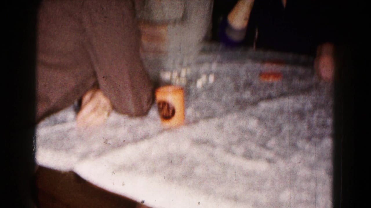 Close view of a covered table edge with a seated person and a cup nearby.