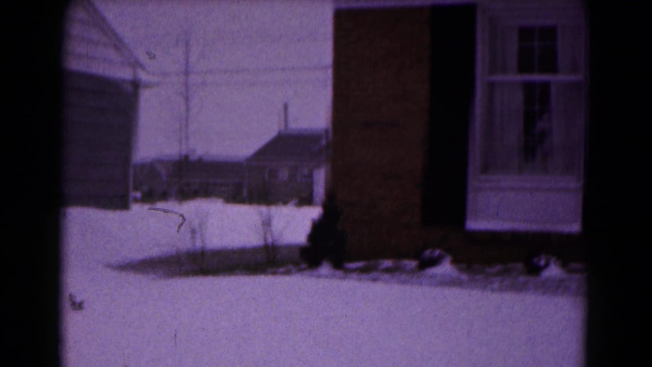 1961 Hagerstown exterior view of a snow-covered front yard and brick house with white-trimmed window.