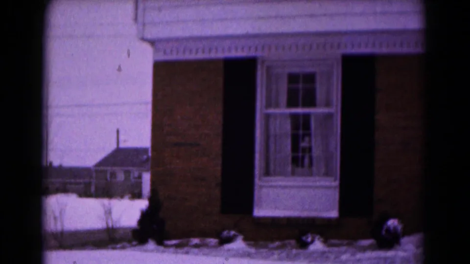 1961 Hagerstown frame showing the front facade of a brick residence with snow along the yard.