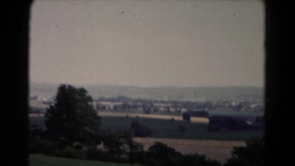1961 8mm view near Hagerstown, Maryland, showing open fields, tree clusters, and distant buildings from an elevated position.
