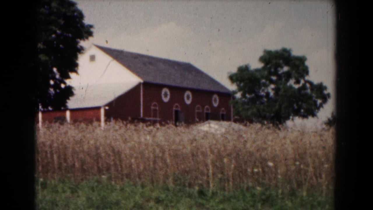 A red barn, nearby trees, and tall grasses appear in a rural 1961 Hagerstown, Maryland farm view.