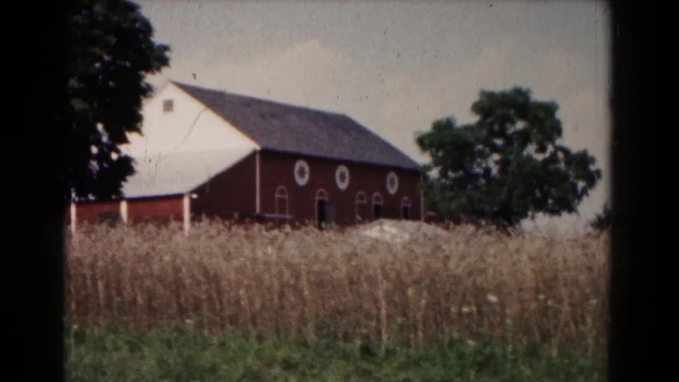 A red barn, nearby trees, and tall grasses appear in a rural 1961 Hagerstown, Maryland farm view.