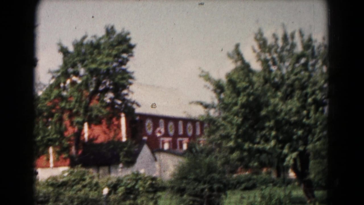 1961 Hagerstown rural exterior with a red barn, white roofline, small outbuilding, and dense summer greenery.