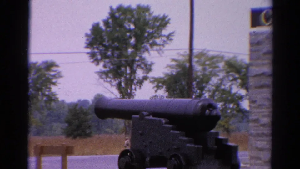1962 Catskill, New York frame showing a closer view of the cannon and wheels, with part of a stone sign entering the right edge.