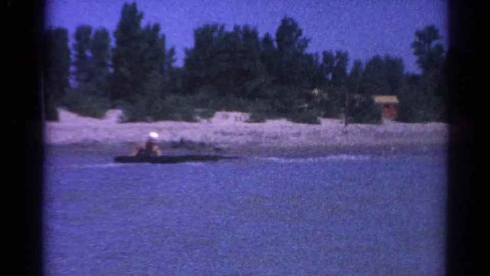 In the 1962 Catskill home-movie footage, the woman appears to lose balance and drop low on the board near shore.