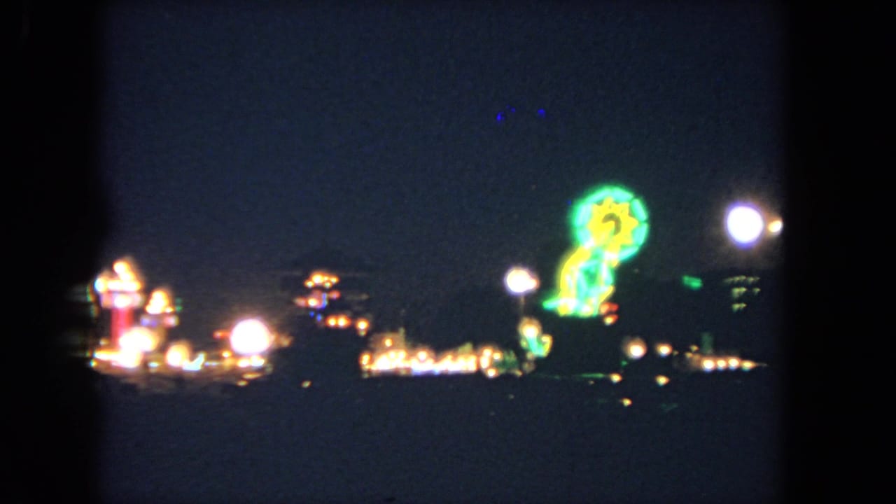 Night carnival scene with glowing ride lights and soft bright attractions.