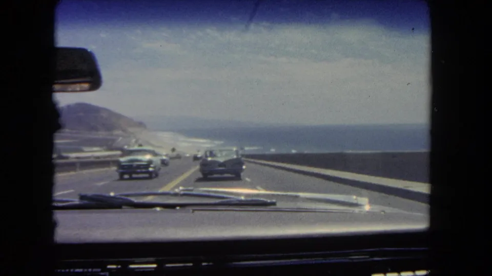 1962 Los Angeles home-movie view from inside a car, following traffic on a coastal highway beside the Pacific Ocean.