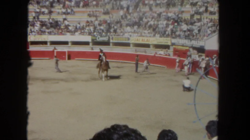 Final rodeo frame shows the horse and rider near several arena figures, red walls, visible signs, and packed grandstands.