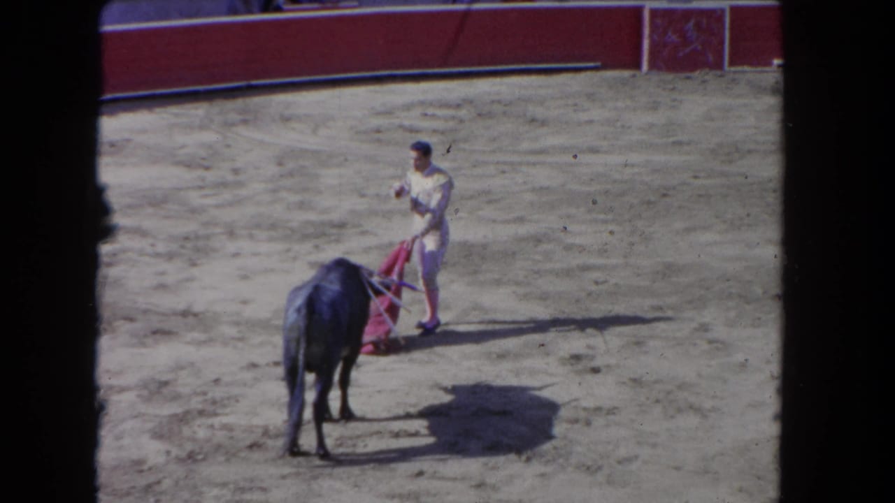Matador in traje de luces executes a cape pass as bull moves in close, 8mm home-movie footage from a bullfight arena circa 1962 per metadata.