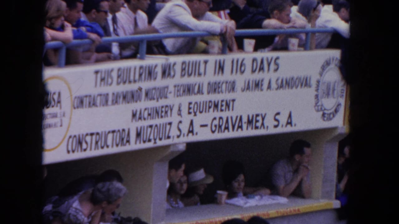 Stadium bleachers with spectators and a large banner reading THIS BULLRING WAS BUILT IN 116 DAYS, crediting Constructora Muzquiz S.A. and Grava-Mex S.A.