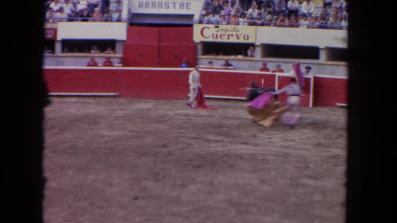 1960s corrida mid-action: matador maneuvering with magenta capote near red barrera, Tequila Cuervo and ARRASTRE signs visible above packed bleachers.