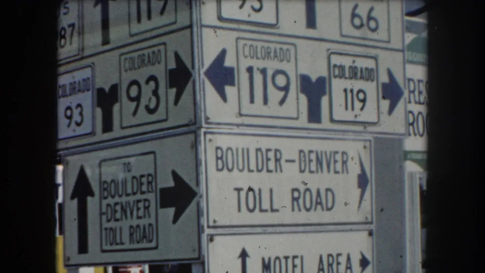 Close-up roadside signpost cluster showing Colorado routes 93, 119, US 287, Colorado 66, and Boulder-Denver Toll Road directions, circa 1962 Summit County, Colorado.