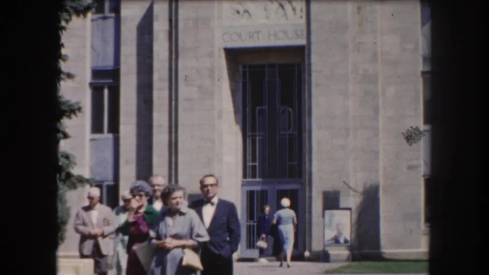 Adults in 1960s clothing gathered in front of a stone courthouse; carved text reading COURT HOUSE is legible above the entrance, Summit County Colorado area, c.1962.