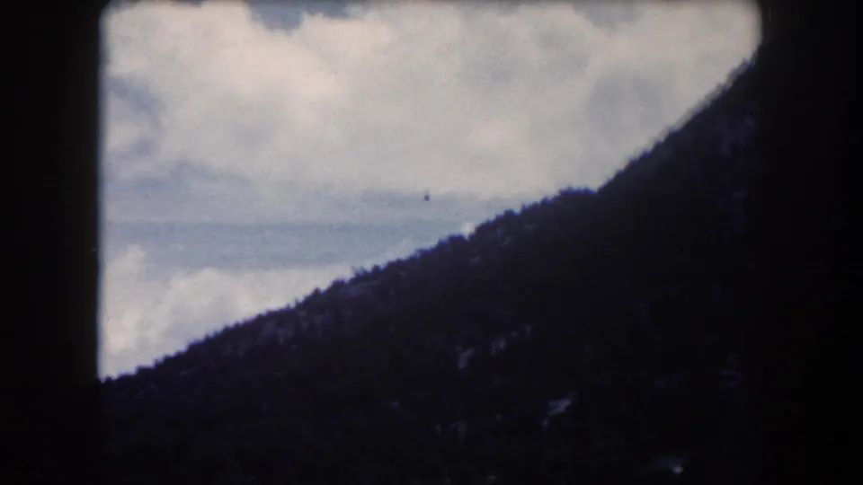 8mm footage circa 1962, panning view of a densely forested mountain slope and cloud-filled sky, Summit County, Colorado.
