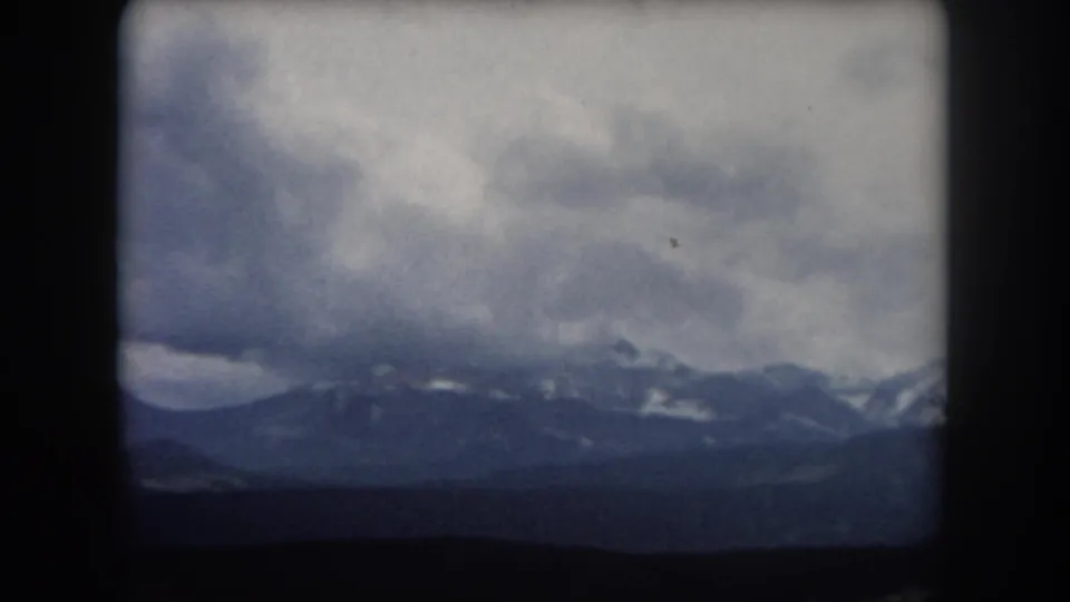 1962 Summit County, Colorado view of a cloud-heavy mountain horizon with muted 8mm color and soft edges.