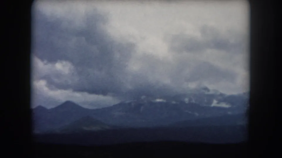 1962 Summit County, Colorado mountain landscape with a broad overcast sky and distant snow on the ridgeline.