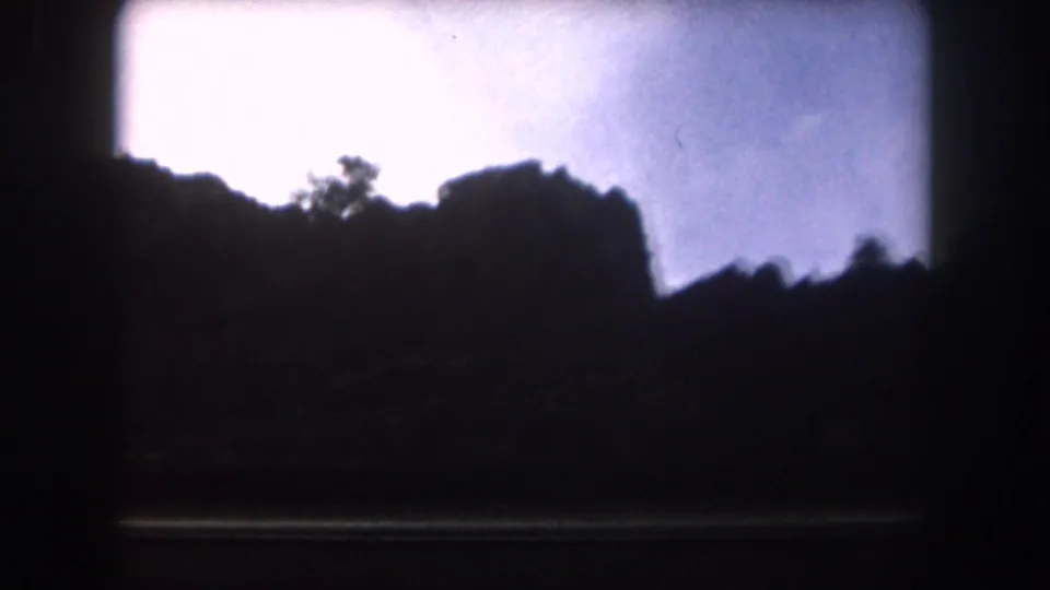 Silhouetted Colorado mountain ridge and pale sky seen through dark vehicle framing near the end of the 8mm clip.