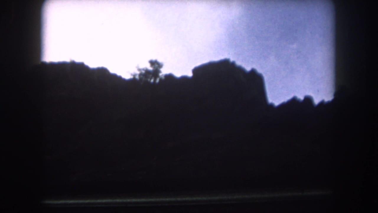Dark mountain ridge silhouette beneath a bright overcast sky.