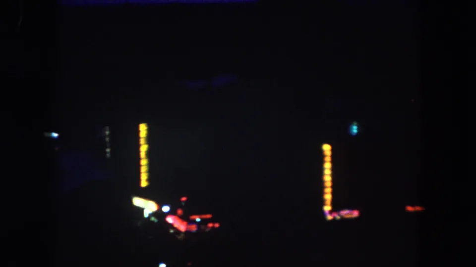 The final 1962 descent frame shows a mostly black Colorado night view punctuated by scattered colored lights and vertical sign glow.