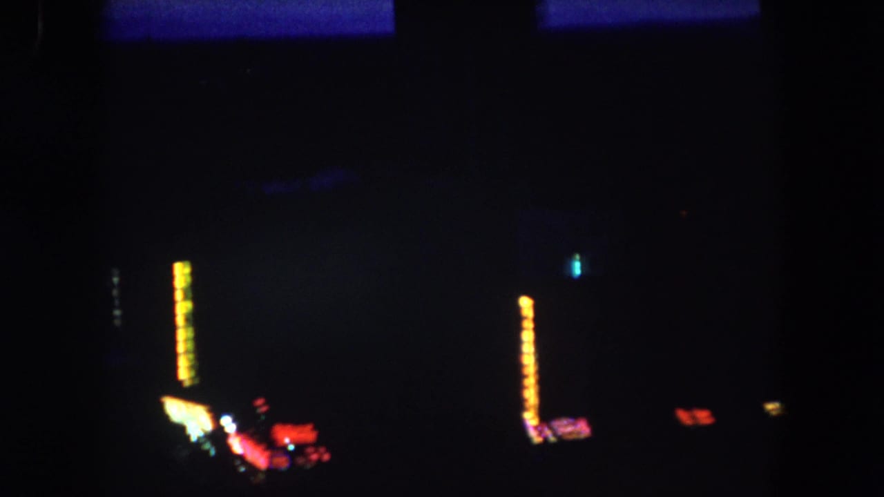 1962 8mm frame from Summit County, Colorado showing a very dark town view with scattered lights and silhouetted structures.