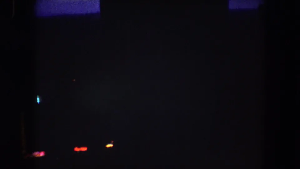 1962 Summit County night scene with dim silhouettes, scattered red and blue lights, and a vertical orange light pattern.