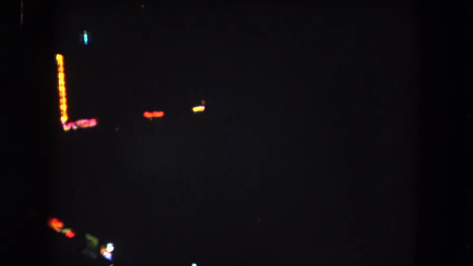 Dim 1962 Summit County night view with a bright orange light row and scattered red, yellow, blue, and green lights.