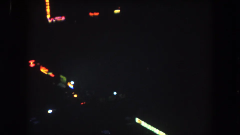 1962 Summit County night traffic view with red and white light streaks, a few blue points, and faint roadside silhouettes.