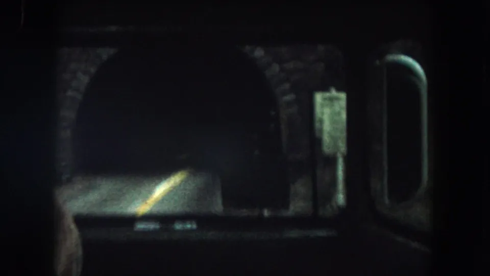 From inside the bus, the tunnel entrance and yellow road line remain visible as the vehicle moves closer.