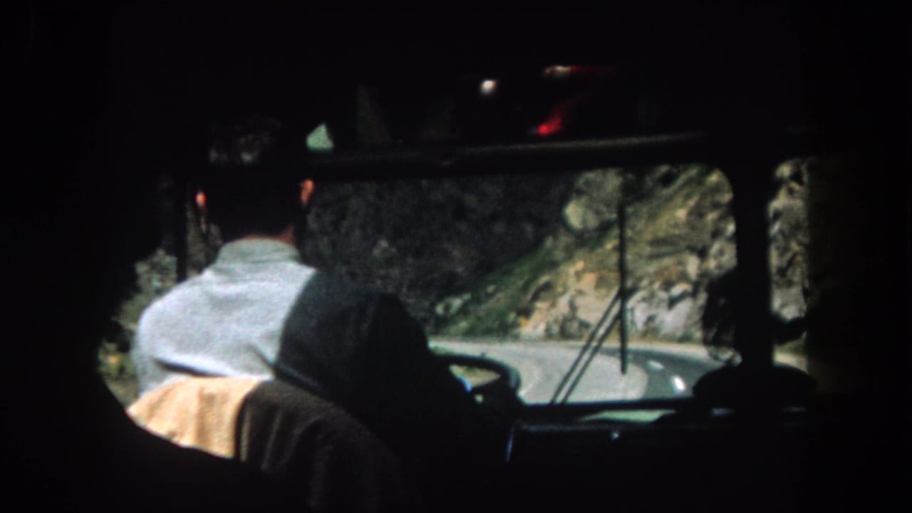 Backseat view of the driver approaching a bend in the road.