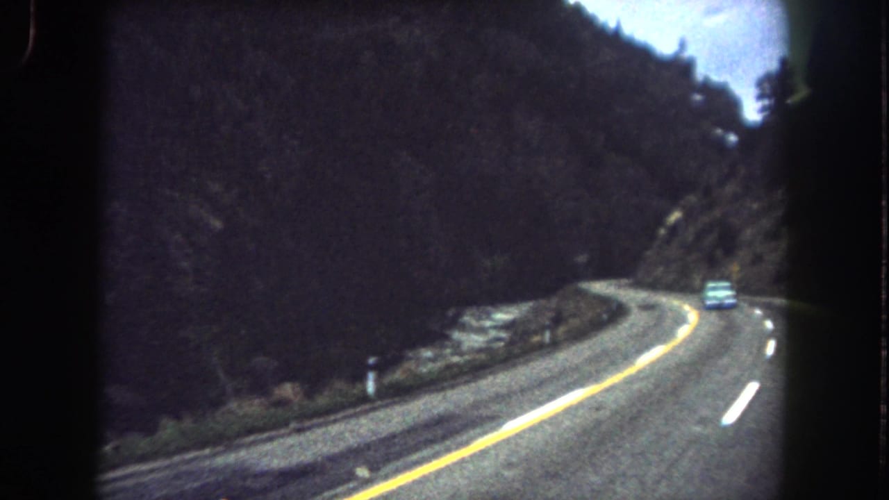 1962 8mm home-movie view of a car traveling along a curving mountain road in Summit County, Colorado.