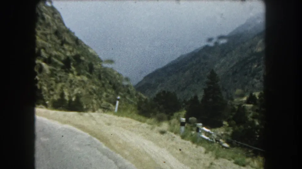 Home-movie frame from 1962 showing a passing roadside view in mountainous Summit County, Colorado.