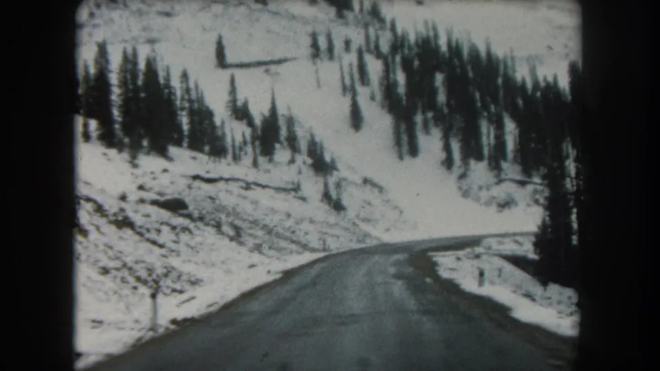 Final frame shows a snowy Summit County roadside slope with evergreens and a paved road curving along the mountain terrain.
