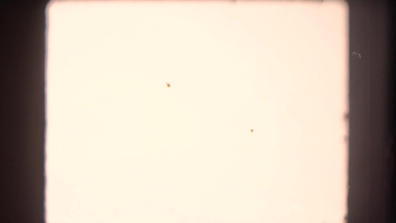 Mostly overexposed film frame with dark borders and faint marks.