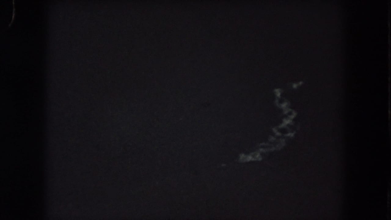 1962 Summit County 8mm frame with an almost black nighttime view and faint, soft light traces near the upper center.